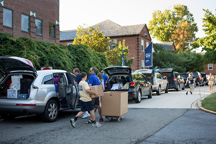 students moving in to residence halls unpacking belongings from car