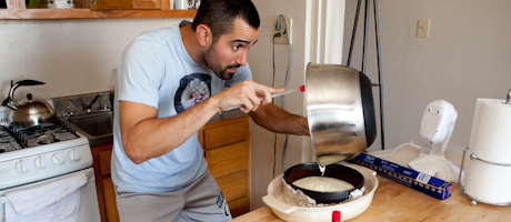 Man pouring cake batter in kitchen