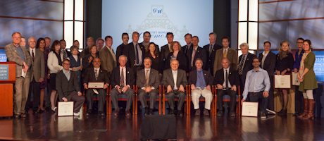 Recipients of Faculty Awards line up in two rows, some seated/some standing with Steven Lerman and Steven Knapp in center