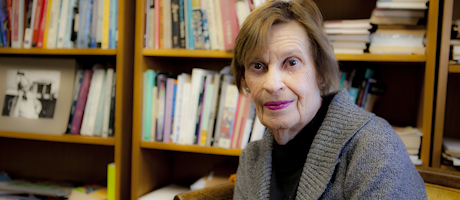 Faye Moskowitz sits with stacks of books behind her