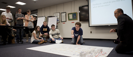 group of people on floor reviewing plans for Gelman Library renovations