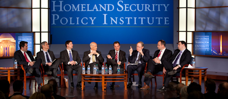 Panelist sitting in chairs in front of Homeland Security Policy Institute backdrop 