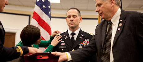 military fellows program member is promoted to major in the U.S. Army with fiancee and Rep. Larry Kissell looking on