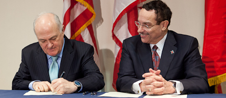 Steven Knapp and DC Mayor VIncent Gray sit together as Knapp signs sustainability pledge