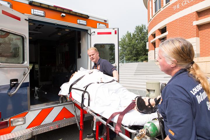 mannequin on stretcher being placed in ambulance