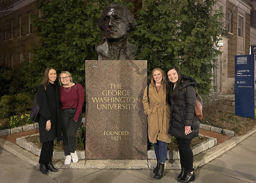 Four people, including Mariefred Evans, stand beside the GW bust 