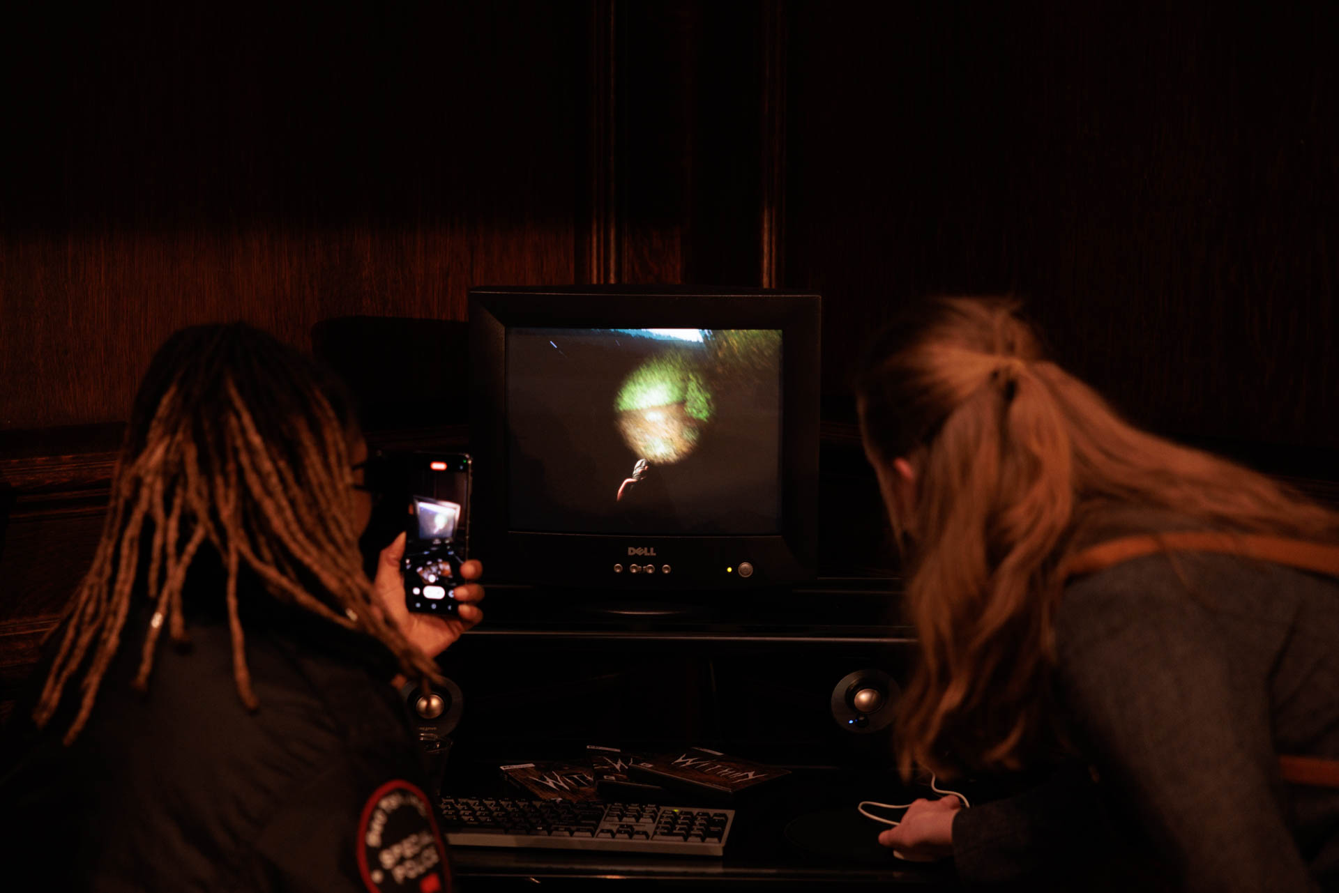 Two visitors study an image on a monitor at NEXT
