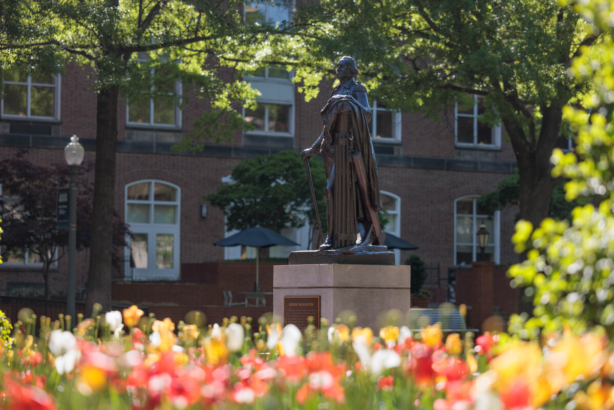 George Washington statue on the GW campus with flowers in the foreground