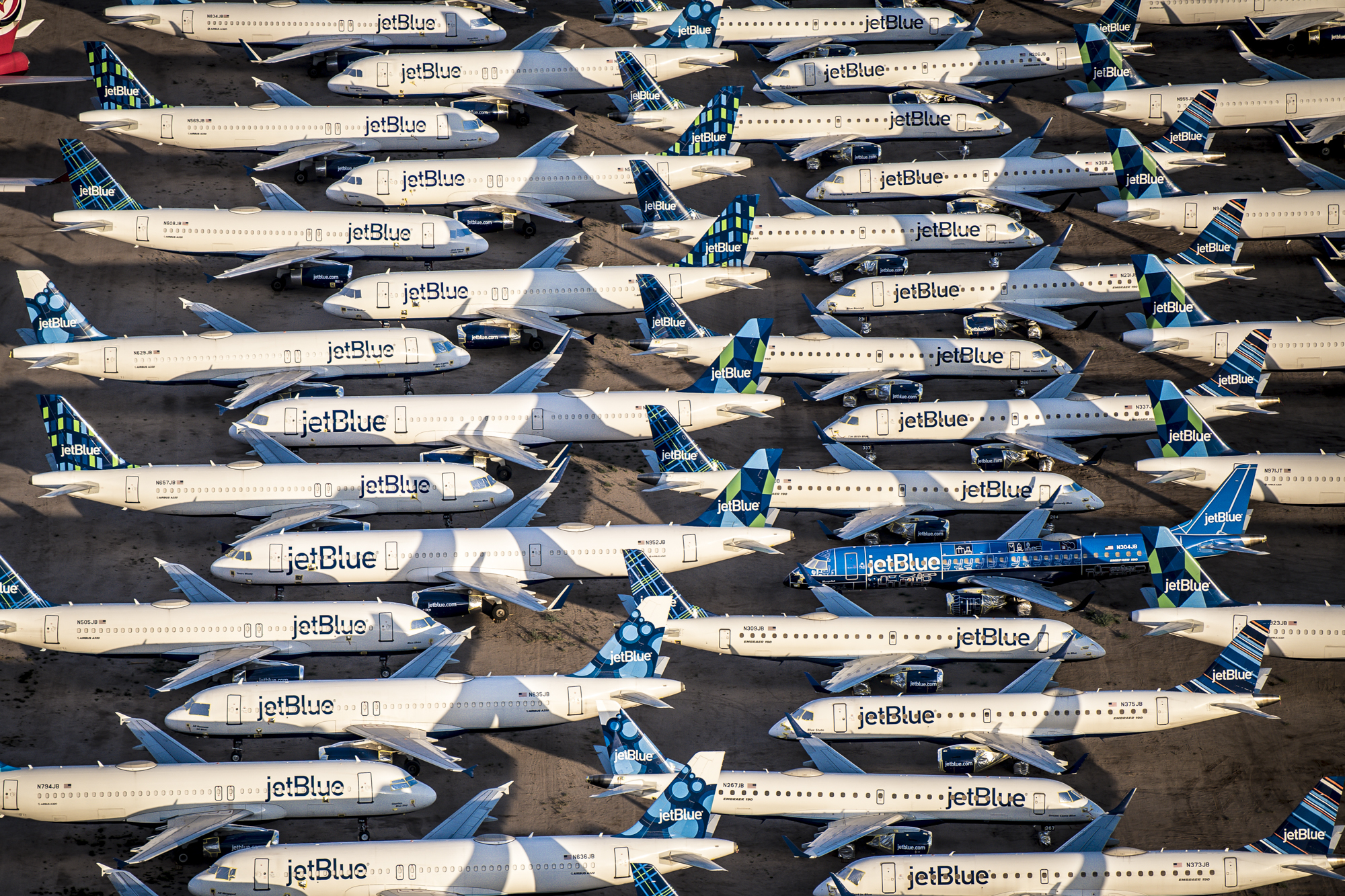 Rows of stored Jetblue airplanes on a runway in Marana, Arizona.