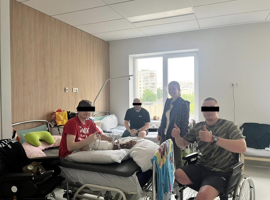 Sarah Malinowski in a hospital room with Ukrainian amputees.