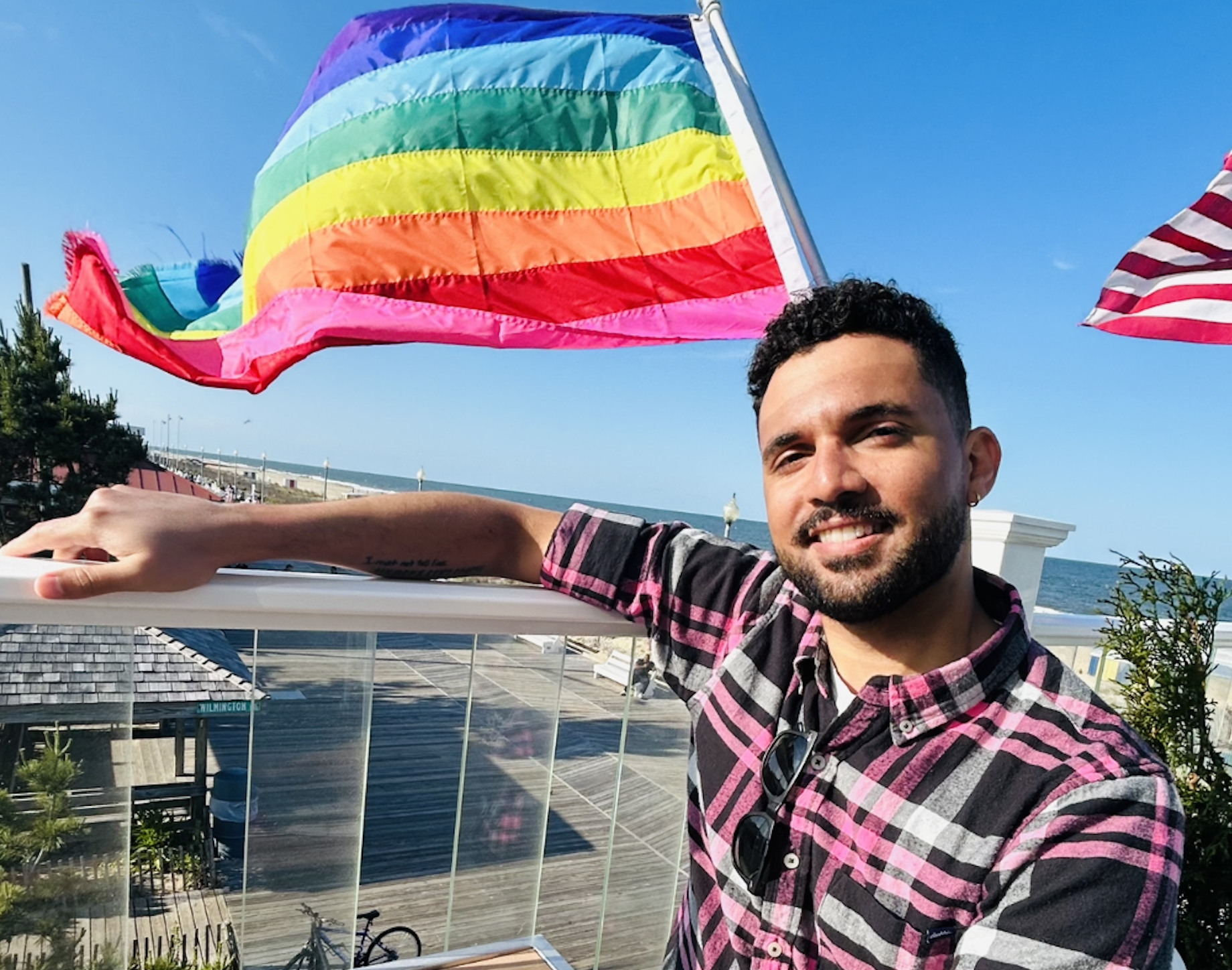 Nick Whims with a pride flag in the background