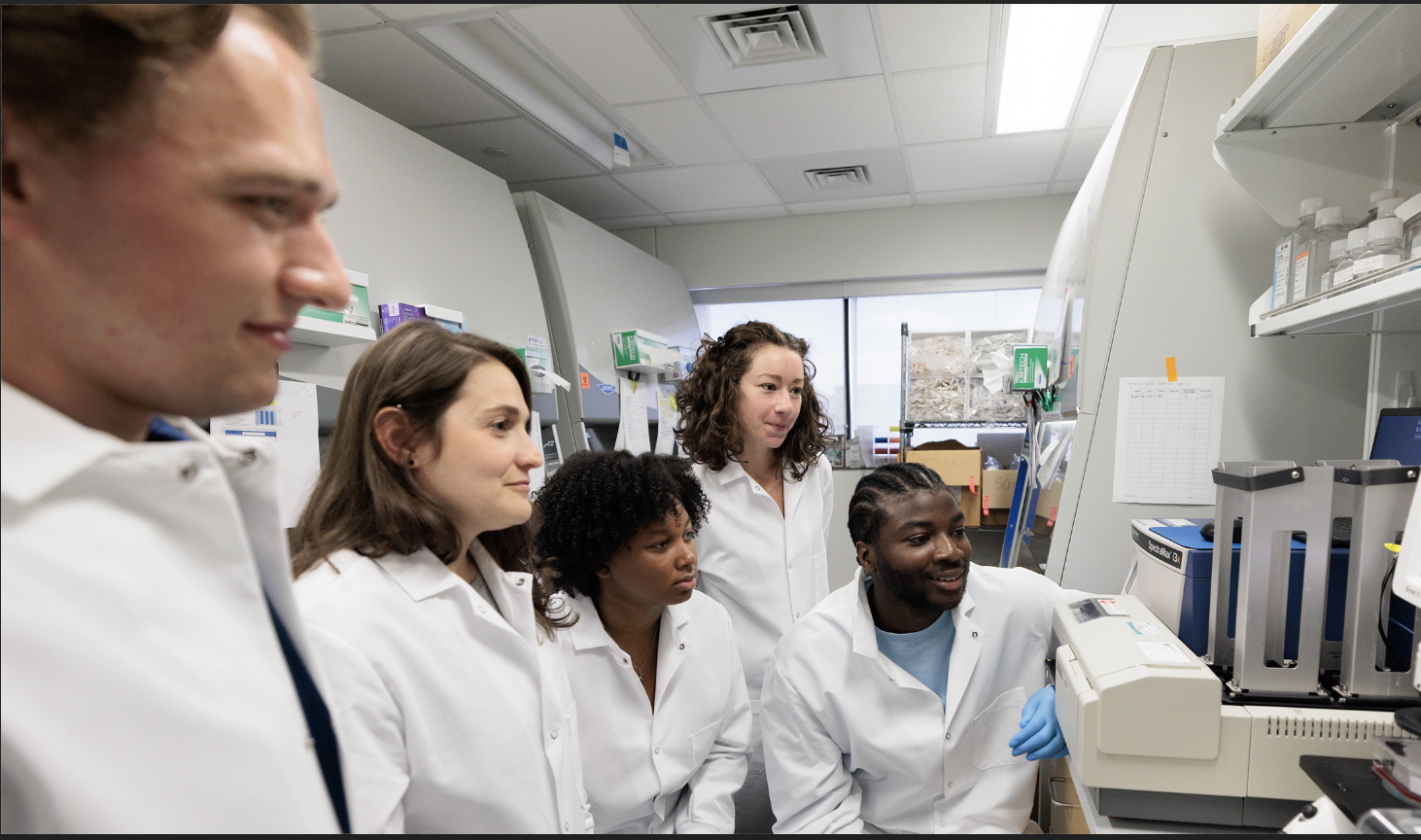 A group of racially diverse men and women working in a research lab