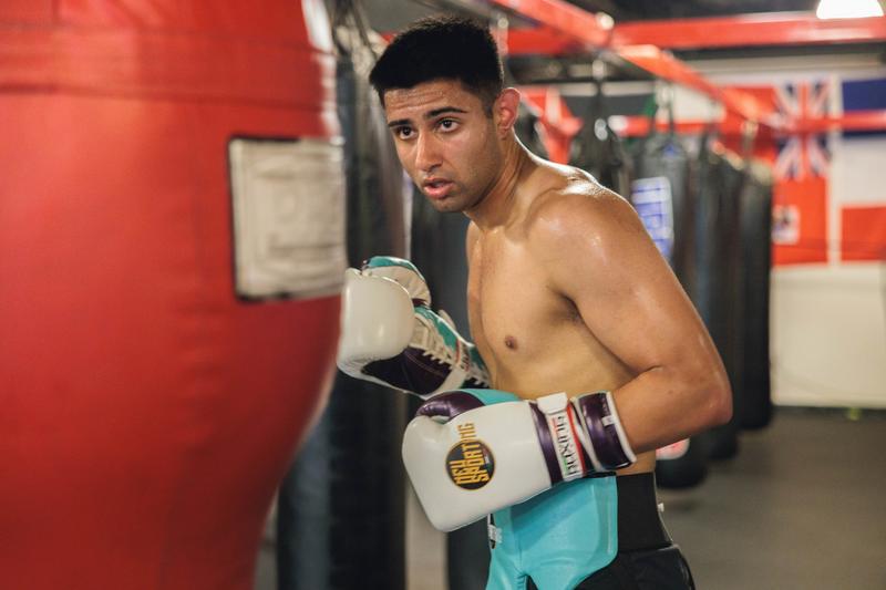 Man stares at boxing bag getting ready to punch
