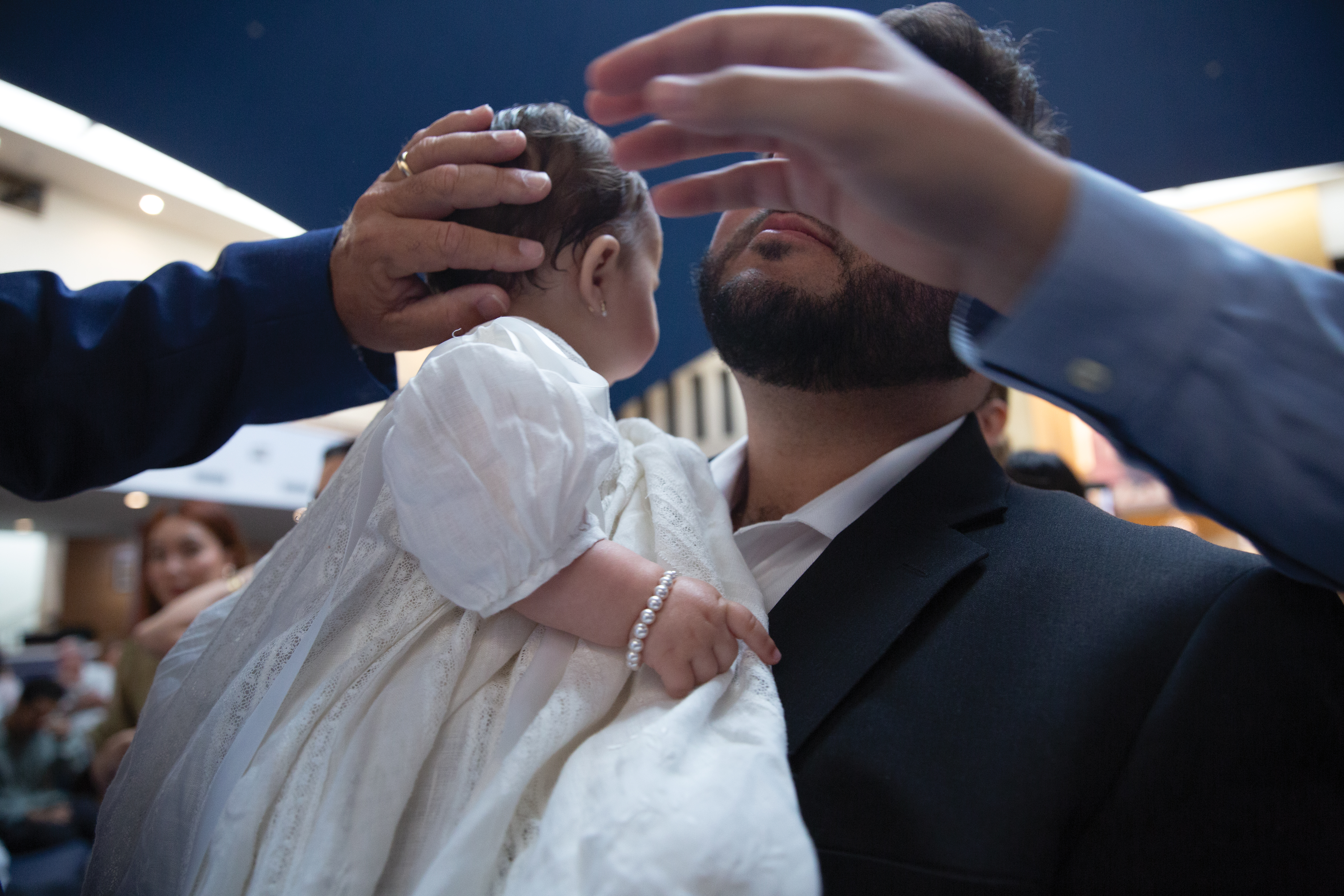 An infant is held at a baptismal ceremony An infant is held at a baptismal ceremony