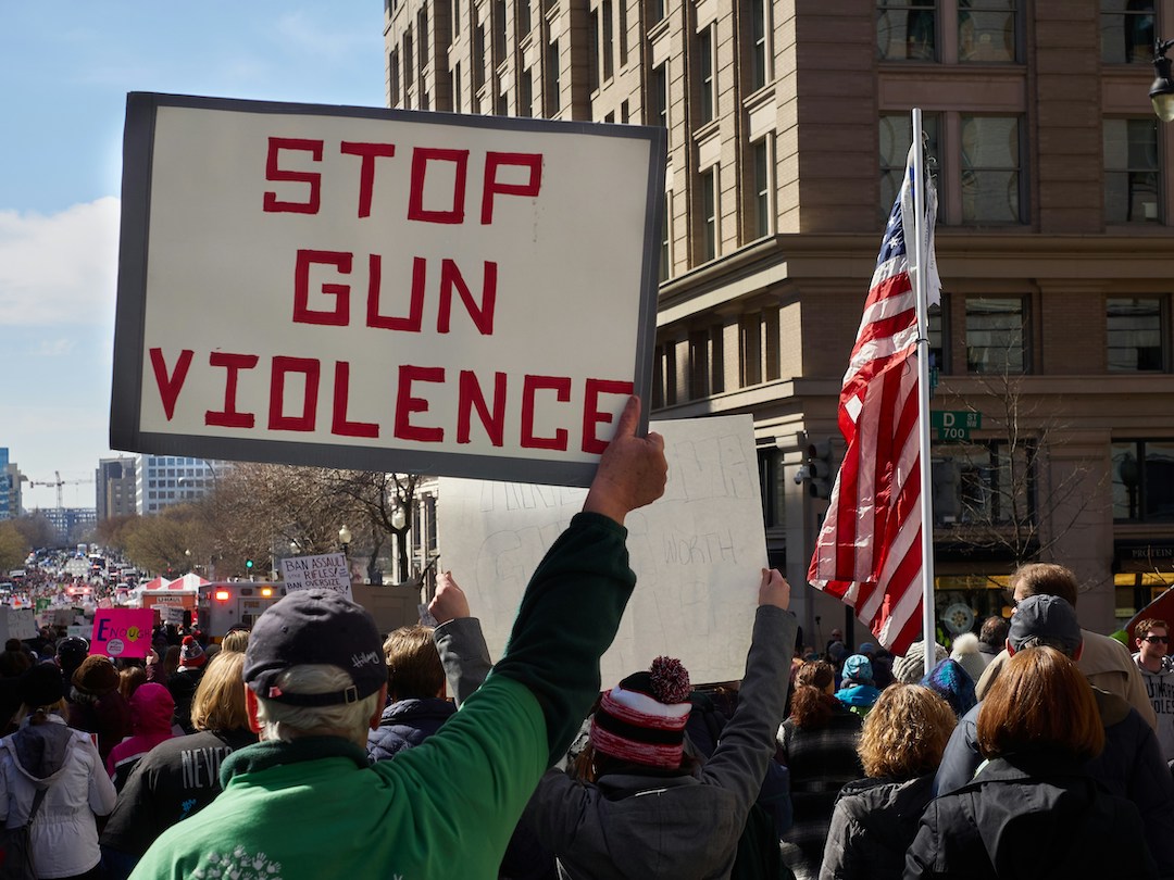 Protester holds "Stop Gun Violence" sign at March for Our Lives (Chip Vincent/Unsplash)