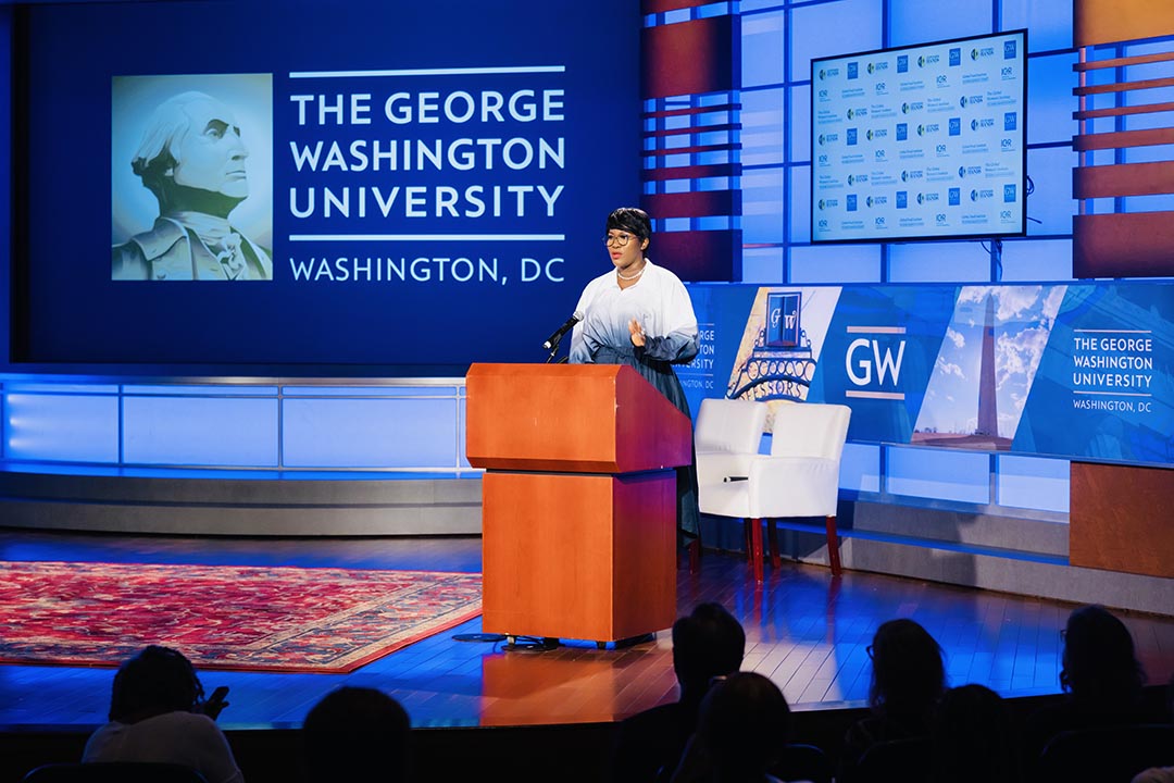 Filmmaker Stephanie Linus speaks from a podium to an audience at GWU.