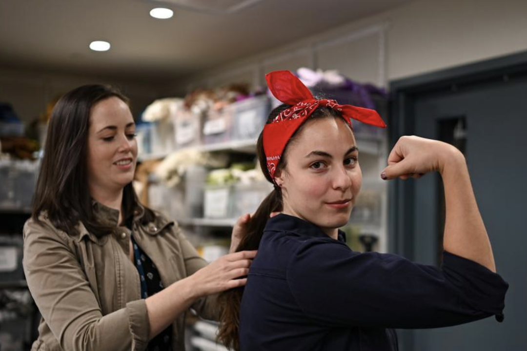 Costumer Emily Vallozzi helps a student with a Rosie the Riveter costume
