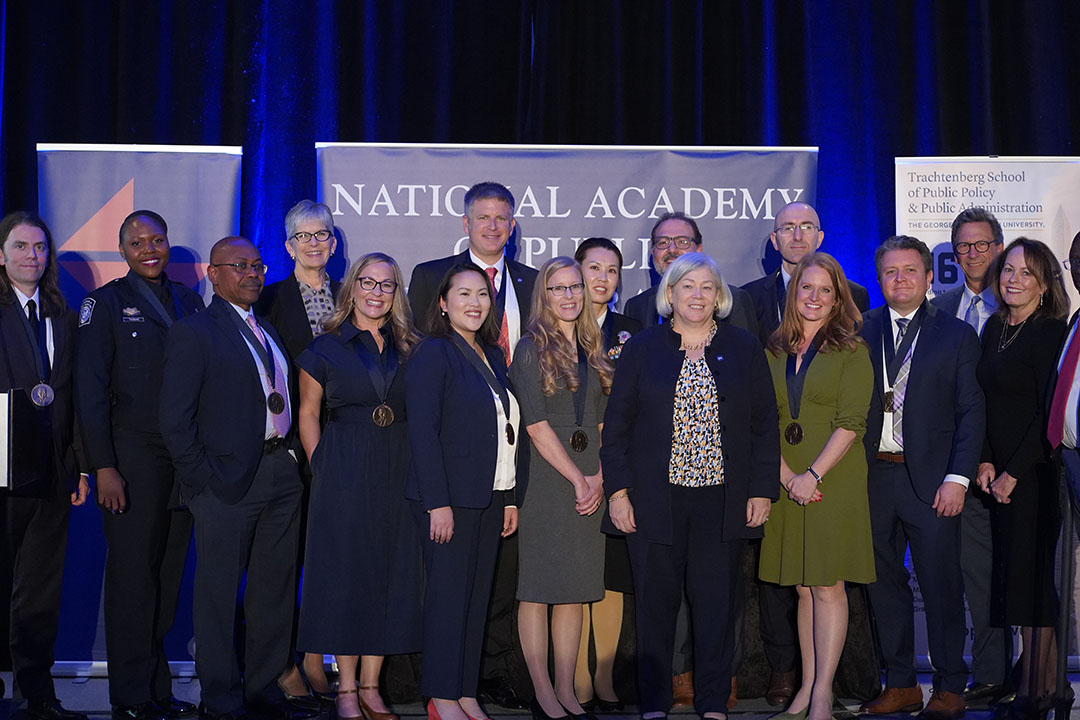 GW President Granberg on a stage with the 12 Flemming Award winners