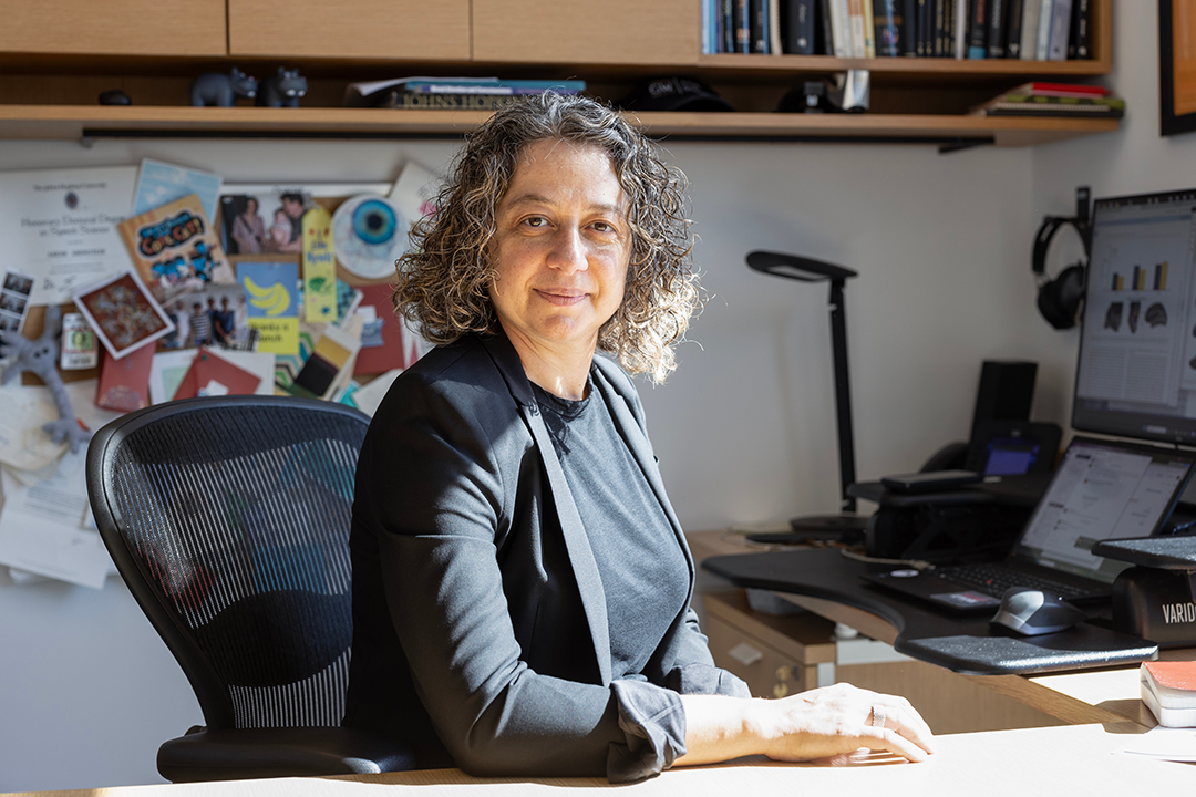Cognitive Neuroscience Professor Sarah Shomstein at her desk in a grey suit