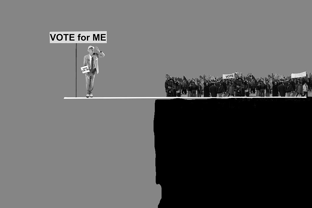 a gray illustration of a man on a platform over a cliff with a sign that reads "vote for me."