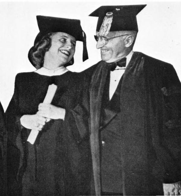 Black and white photo of Margaret Truman smiling up at her father, President Harry S. Truman. Both are wearing mortarboards and graduation robes