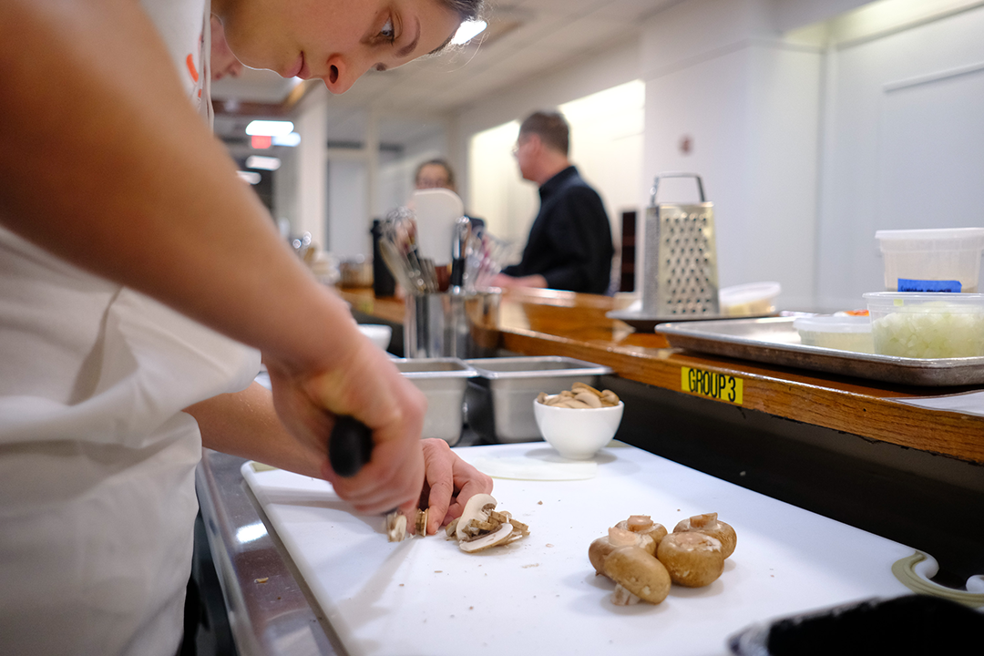 Junior Olivia Paquette chopping mushrooms for a risotto.