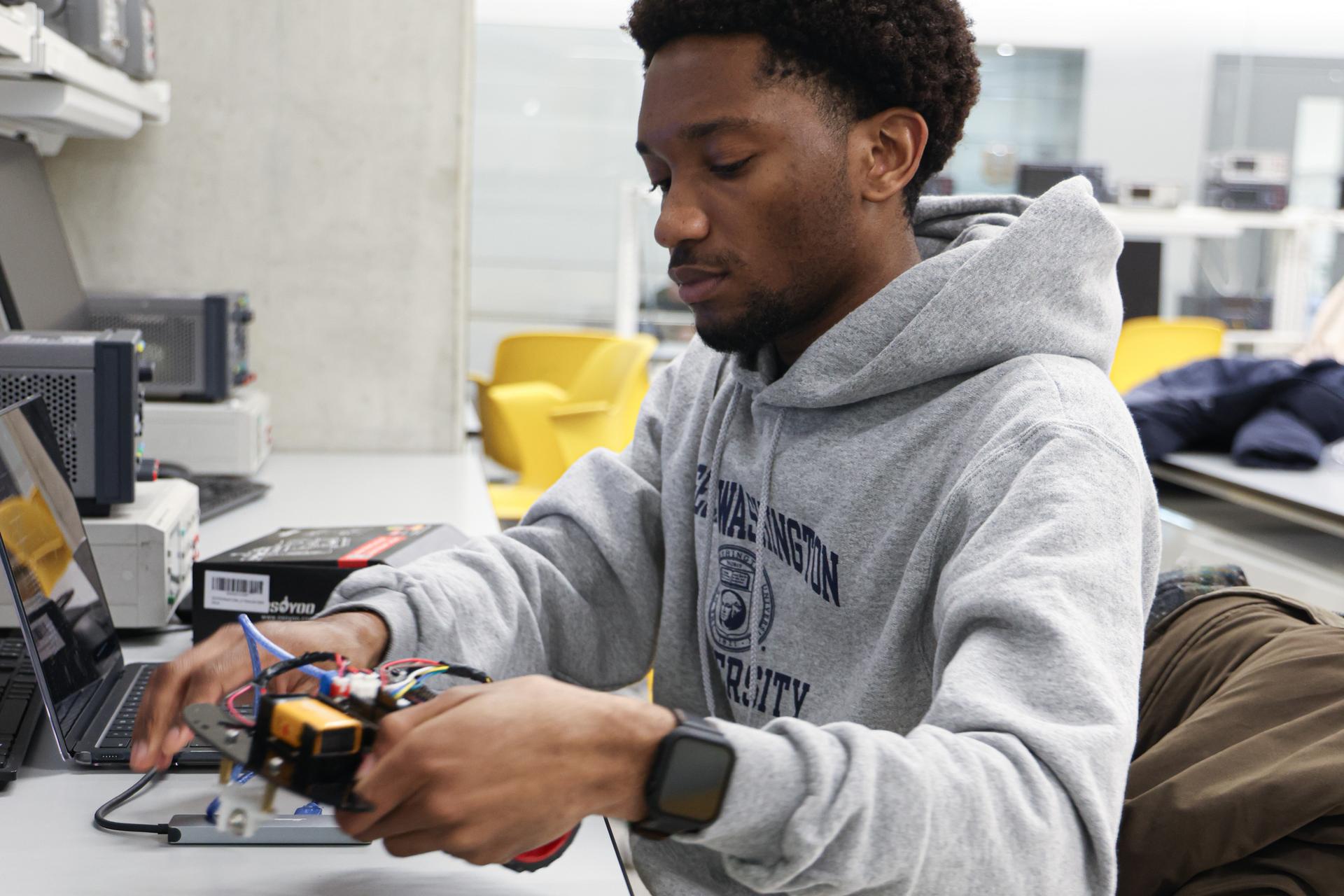 Gbaba works with his robot, Tobor, in his electrical engineering lab Gbaba works with his robot, Tobor, in his electrical engineering lab