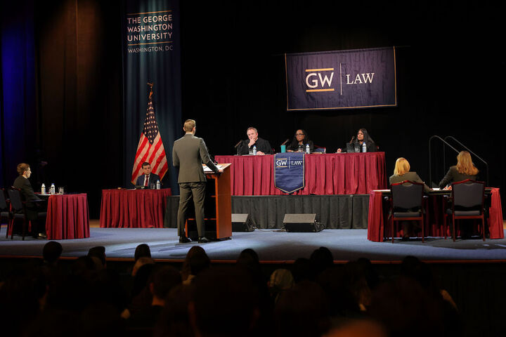 GW Law student William Schubert, center, addresses the judges on the bench. With Jordan Marcum, seated at left, he represented the petitioners before Chief Judge David J. Barron, Justice Ketanji Brown Jackson, and Judge Roopali H. Desai.