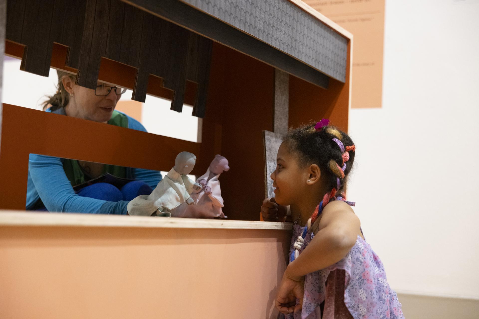Photo: Cara Taylor A woman operates puppets for a young party guest