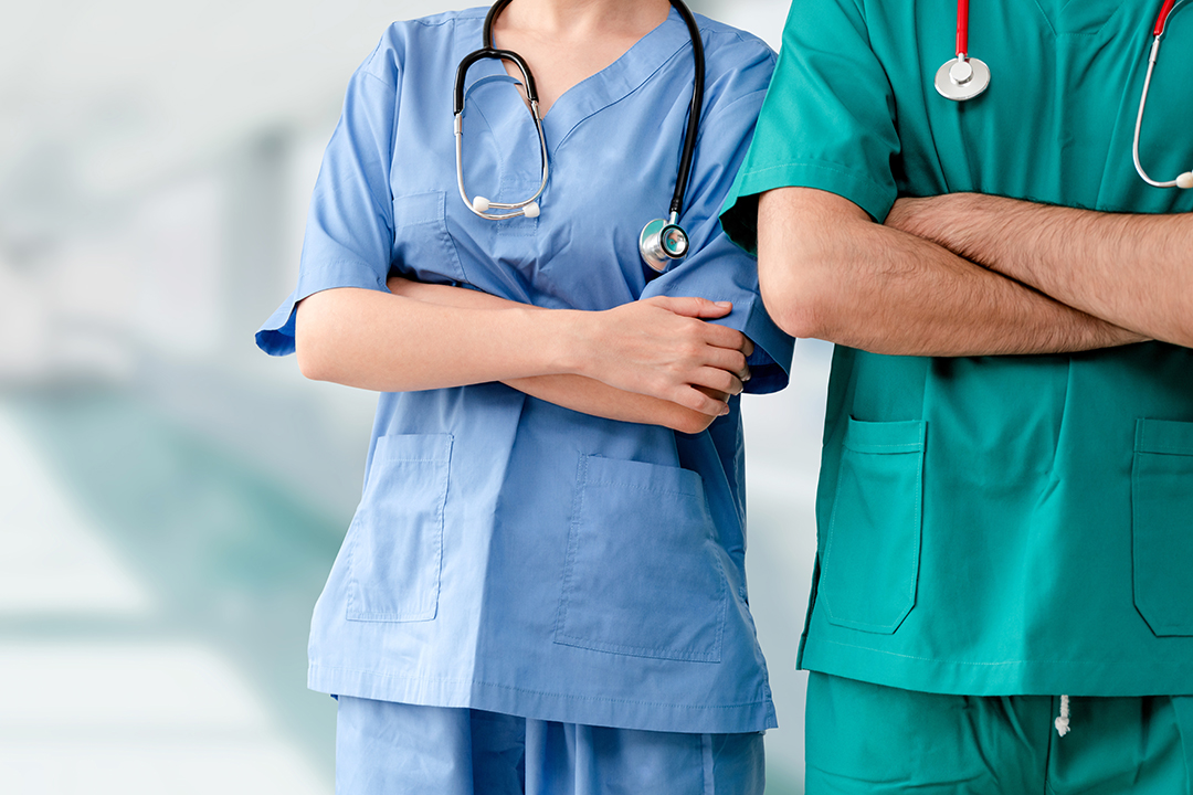 Nurses pose in hospital scrubs
