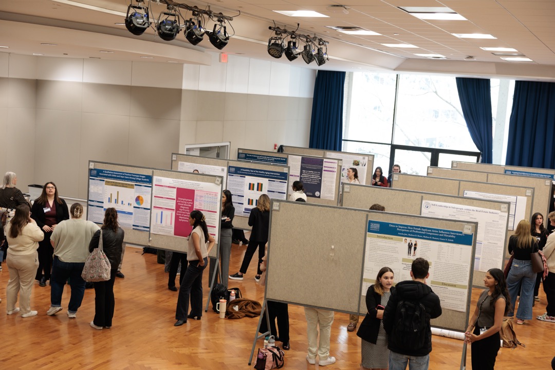 CCAS Research Showcase student posters with crowd