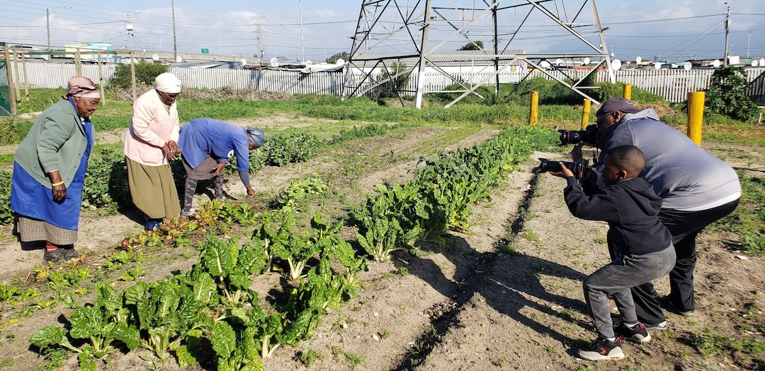 Michael Cheers working as a photojournalist in a field