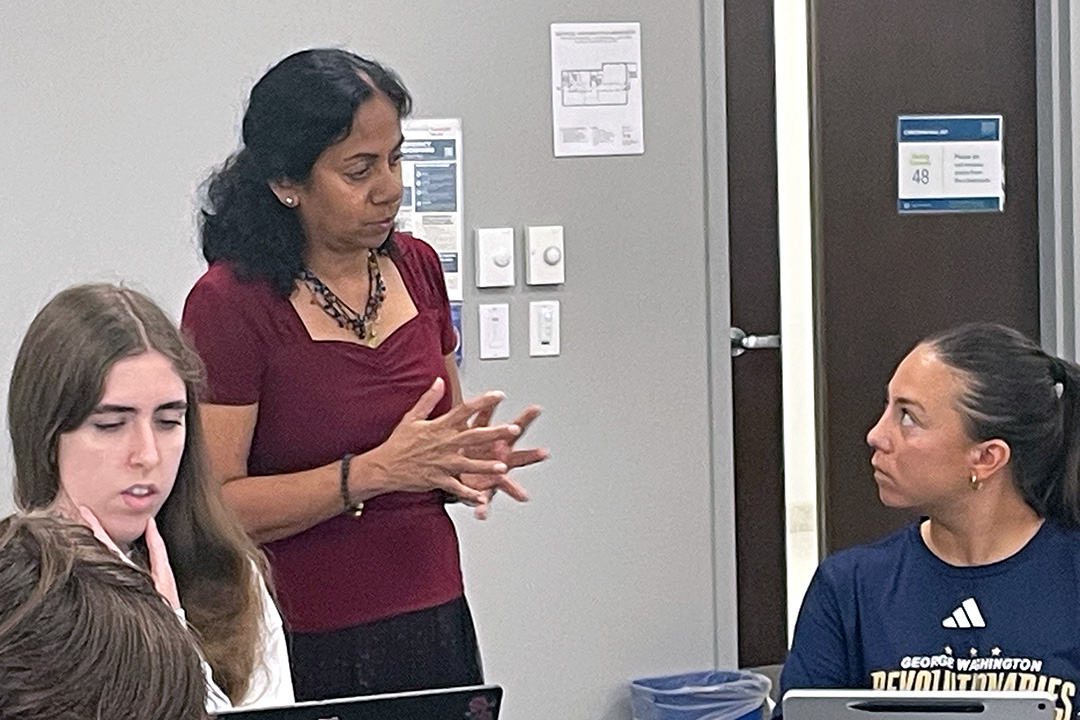 Geography Professor Elizabeth Chacko in class with 2 students