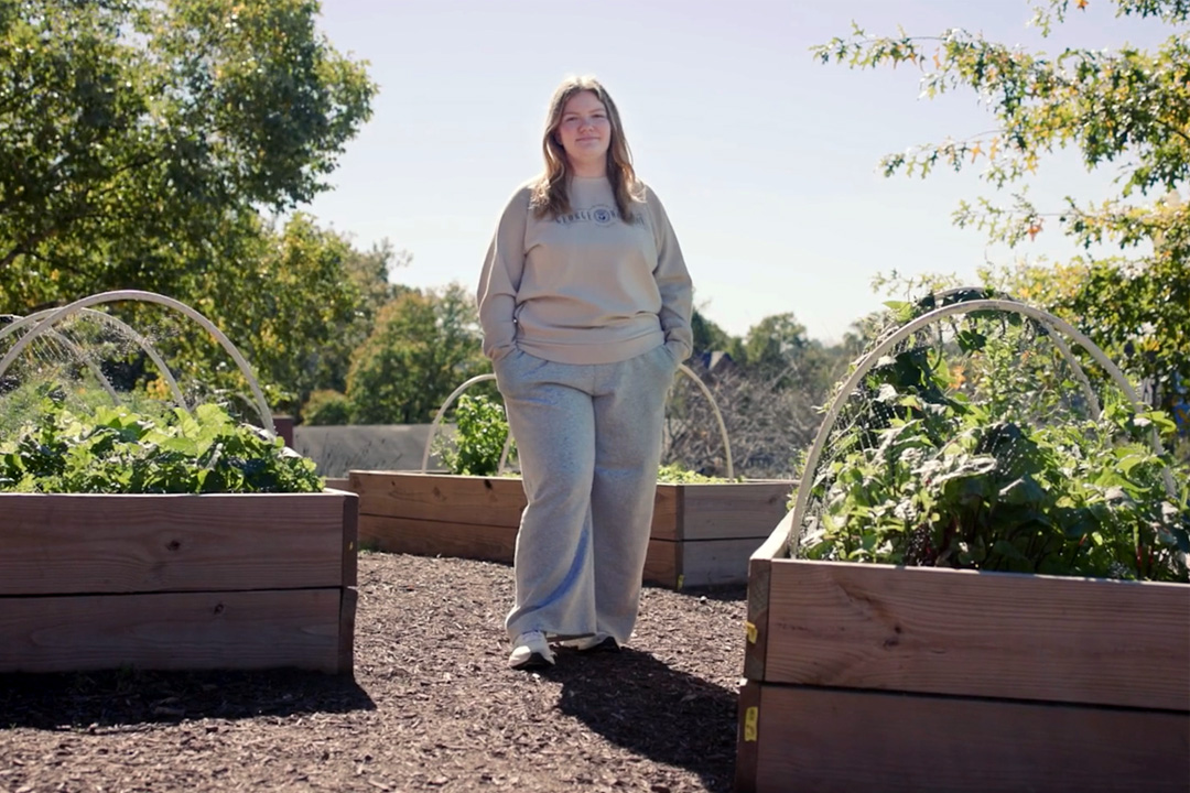 Riley Whitlock standing in front of plant beds