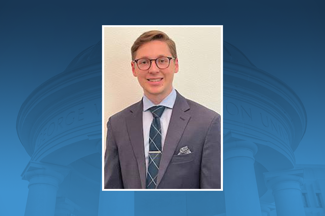 Photo of Andy Tomusiak, a young man in grey suit and blue tie