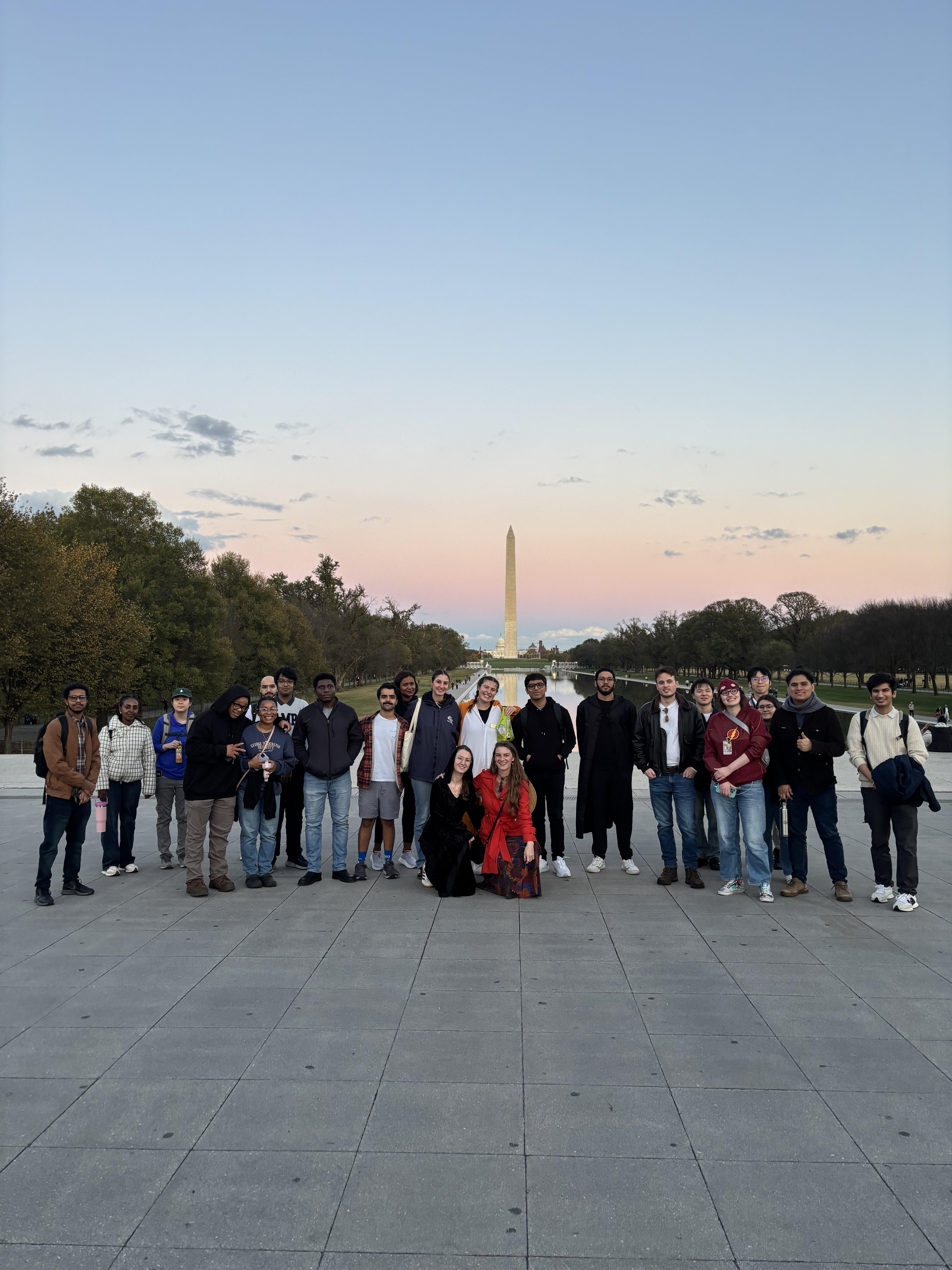 Graduate students, pictured with the Washington Monument in the background, toured D.C. monuments at Halloween.