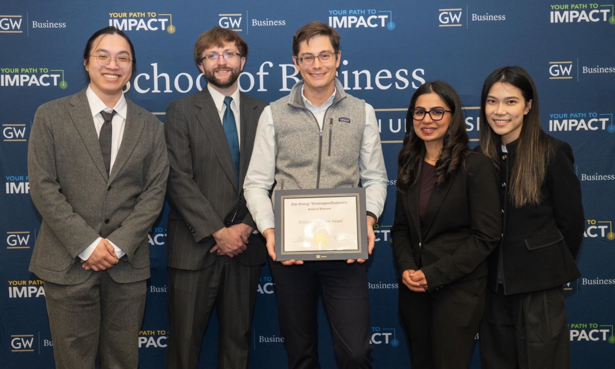 Team members Maryam Shahbaz Ali, Tyler Ordiway, Zihui Chen and Pingyi Xu gather for a photo with Professor Patrick Hall after winning an AI competition for their chatbot, FraudLens.