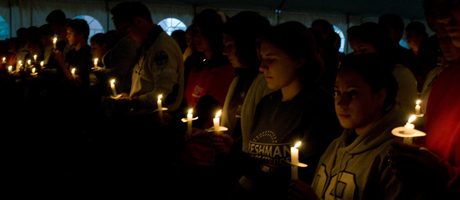 students in dark at candlelight vigil 
