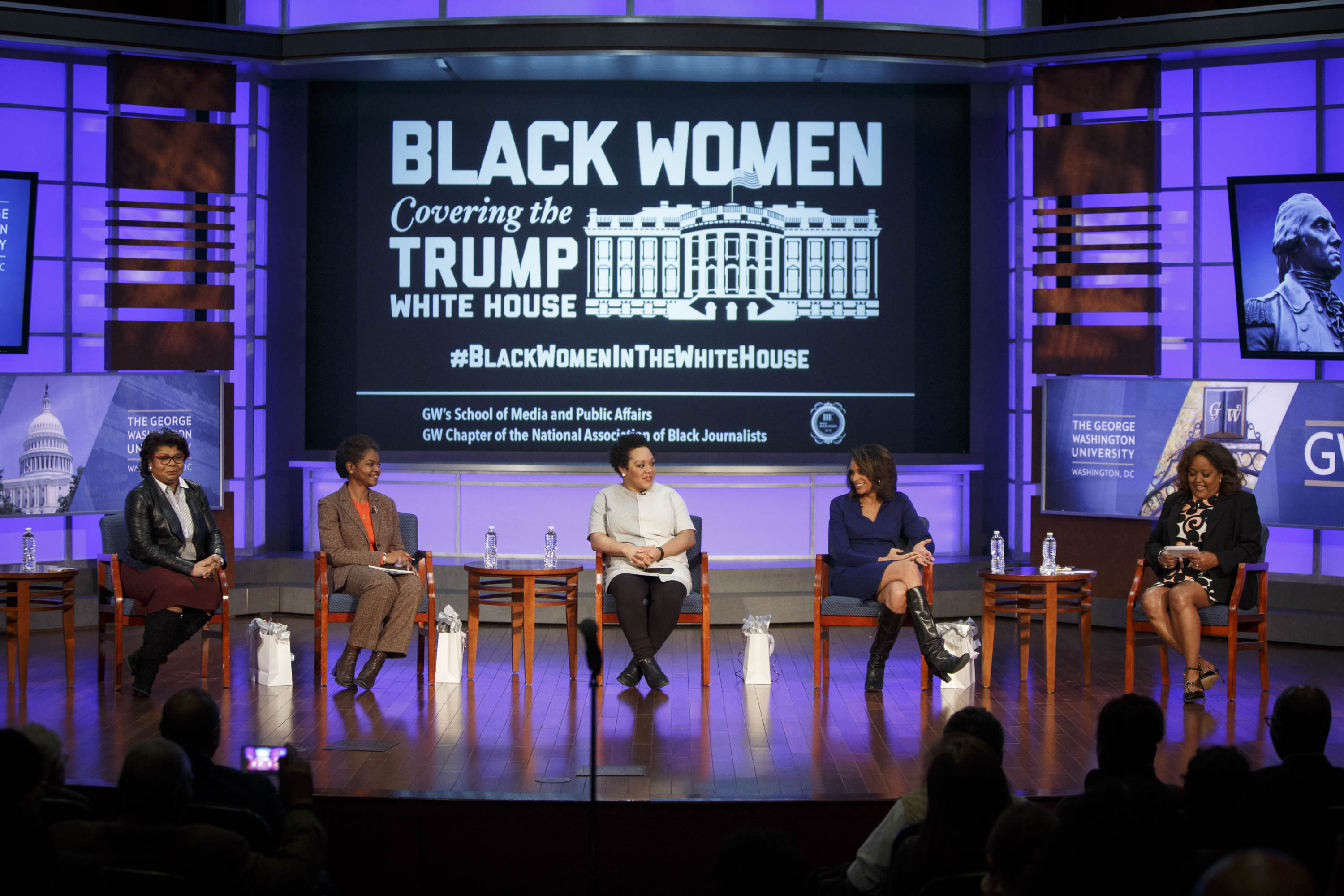 "Black Women Covering the White House" on screen with panelists seated on stage in front of screen