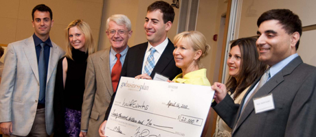 winners of business plan competition with oversized check smiling
