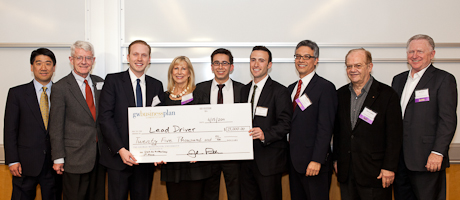 Winners of Business Plan Competition hold oversized check with leaders of the competition 