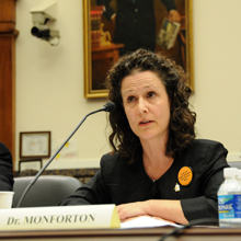 Celeste Monforton speaks sitting down at table into microphone