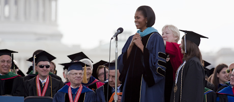 Michelle Obama receives honorary degree with the U.S. Capitol in the background and members of the university community looking 