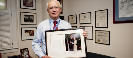 Dr. Joseph Giordano holding framed letter and picture from First Lady Nancy Reagan