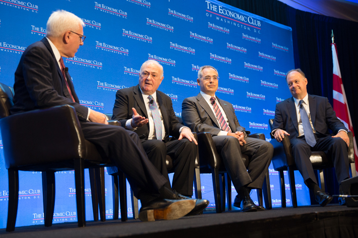 Steven Knapp speaks on stage with three other college presidents during panel discussion