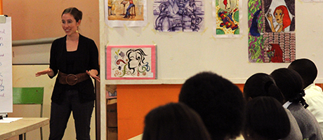 Emily Perreault speaks in front of room to a group of Kenyan students at the Nairobi National Museum