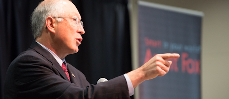 Ken Salazar points while talking into microphone
