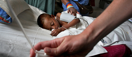 child in hospital bed receiving care