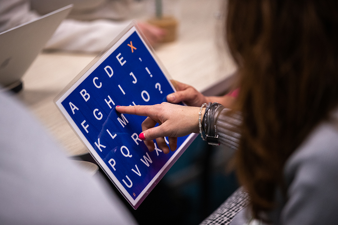 An autistic young adult in Sean Cleary's "The Experience of Autism" class uses an alphabet board to communicate. (Harrison Jones