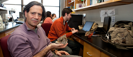Guillermo Orti seated in office holding fish 